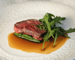 half-cooked lamb meat with arugula