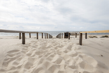 Fototapeta na wymiar Beautiful beach with sand and wooden walkway by the ocean