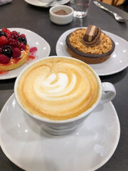 cafe con leche con torta de chocolate y frutos rojos