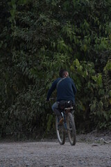 Hombre manejando bicicleta en selva peruana 