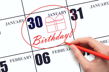 The hand circles the date on the calendar 30 January, draws a gift box and writes the text Birthday. Holiday.