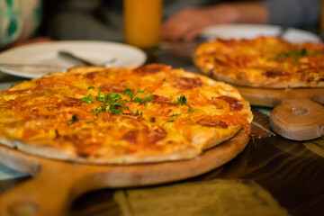 Pizza on the table in a cafe, fast food, eating and people concept - close up