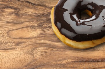 Sweet tasty chocolate glazed donut on the desk
