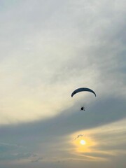 Paragliding concept, paraglider pilot fly in sunset sky . Copy space