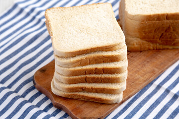 Slices of White Bread on a Rustic Wooden Board, side view.