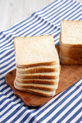 Slices of White Bread on a Rustic Wooden Board, side view. Close-up.