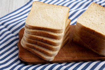 Slices of White Bread on a Rustic Wooden Board, side view.