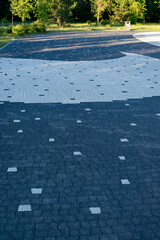 laid paving slabs of light and dark gray colors in the park in the city in summer