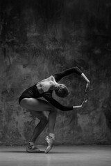 Young beautiful ballerina is posing in studio - obrazy, fototapety, plakaty