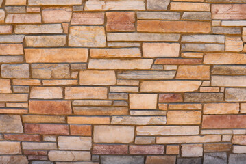 A multi-colored outdoor stone tile wall background. 