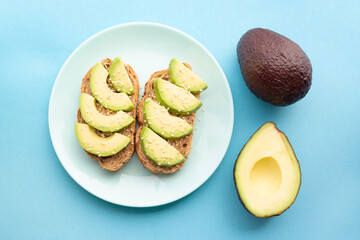 Fresh avocado, bread and sesame sandwich. Food for a healthy diet. Flat lay. Top view. Tasty breakfast. Ripe exotic fruit.