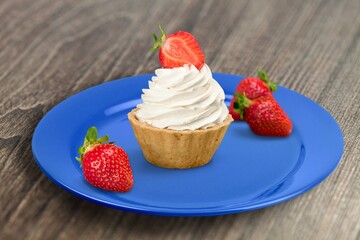 Tasty sweet dessert with strawberry and cream on the desk