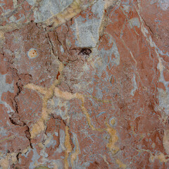 Red marble with large white flecks and vertical veins