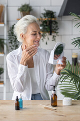 Beautiful senior woman doing beauty treatment procedures at home. Concept of skin care of mature...