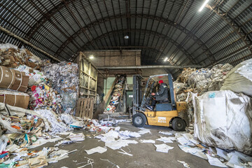 Waste paper sorting and filing for processing at paper recycling plant. Production of new paper from garbage.
