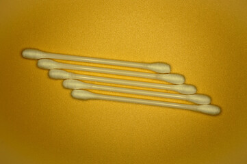 White cotton buds on an orange background.
