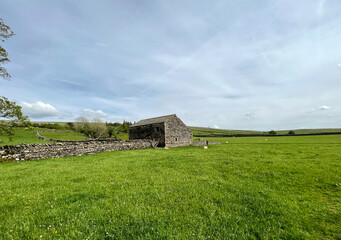 Fototapeta na wymiar Yorkshire Dales landscape, with large fields, an old stone barn, and heavy clouds above near, Dovecote, Horton in Ribblesdale, UK 