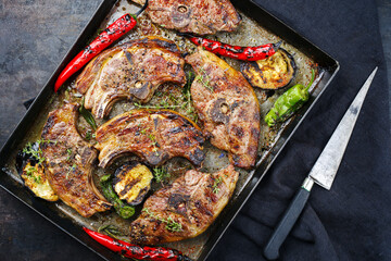 Barbecued lamb saddle back chop steaks with chili and eggplants served as top view on a rustic...