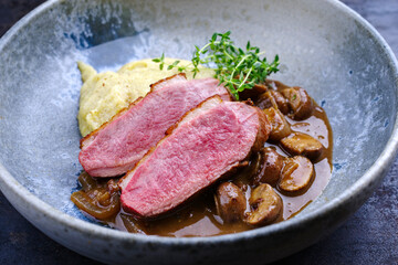 Barbecue gourmet duck breast filet with polenta and caramelized mushrooms in hearty beer sauce...