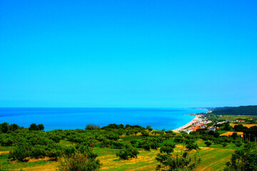 Fototapeta na wymiar Fantastic overview from the San Giovanni in Venere abbey with huge swathes of deep green land descending to the populated coastline and perfect blue waters on a sunny day