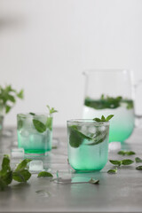 Glass of cold water with fresh mint leaves and ice cubes