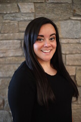woman in black standing in front of stone wall