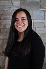 woman in black standing in front of stone wall