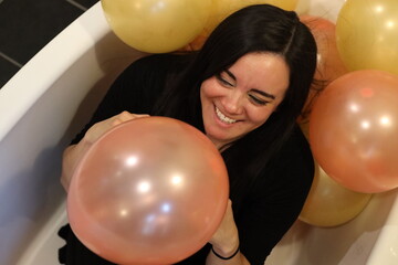 cheerful woman surrounded by balloons at a party