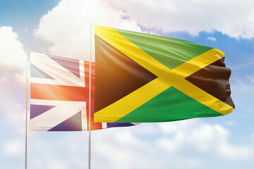 Sunny blue sky and flags of jamaica and great britain
