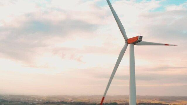 Wind turbines at sunrise in heavy fog. Wind farm generating green energy