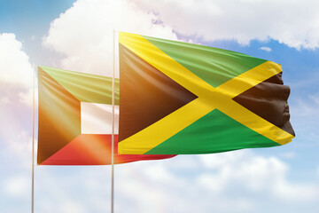 Sunny blue sky and flags of jamaica and kuwait