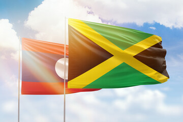 Sunny blue sky and flags of jamaica and laos