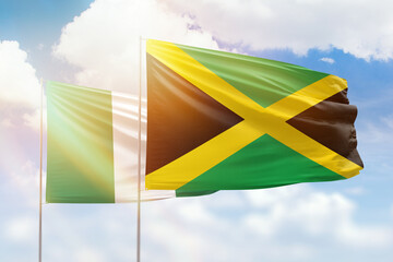 Sunny blue sky and flags of jamaica and nigeria