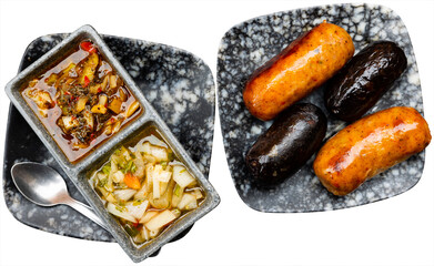 Juicy grilled creole sausages served with pickled vegetables. Isolated over white background