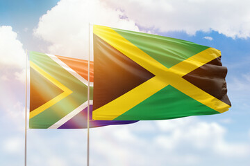 Sunny blue sky and flags of jamaica and south africa