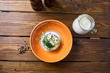 Okroshka with dressing on a wooden table