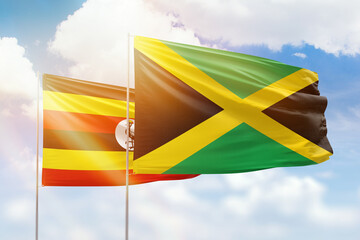 Sunny blue sky and flags of jamaica and uganda