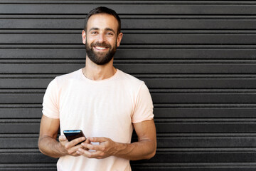 Portrait of handsome smiling hispanic man using mobile app shopping online, copy space. Happy...