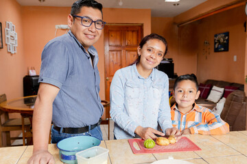 Small Latin family cooking healthy food at home - Hispanic housewife preparing food together with...