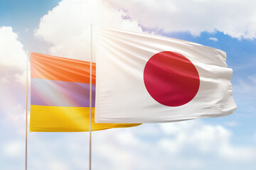 Sunny blue sky and flags of japan and armenia