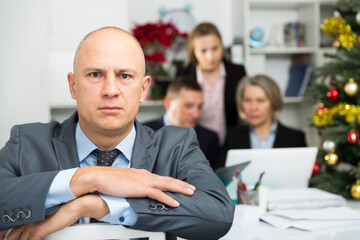 Business team tensely solving problems in office with offended man foreground. High quality photo