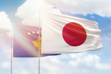 Sunny blue sky and flags of japan and kosovo