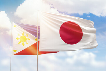 Sunny blue sky and flags of japan and philippines