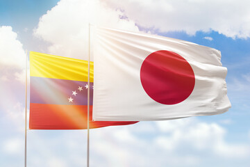 Sunny blue sky and flags of japan and venezuela