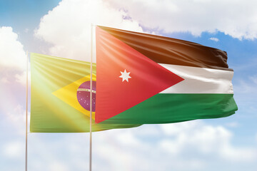 Sunny blue sky and flags of jordan and brazil