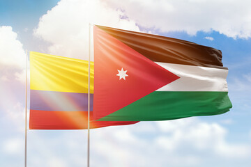 Sunny blue sky and flags of jordan and colombia