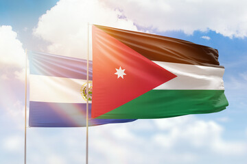 Sunny blue sky and flags of jordan and el salvador
