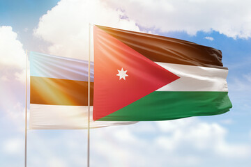 Sunny blue sky and flags of jordan and estonia
