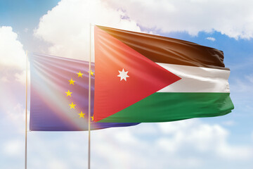 Sunny blue sky and flags of jordan and european union