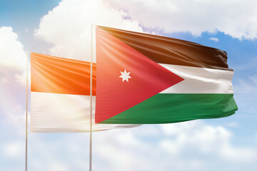 Sunny blue sky and flags of jordan and indonesia